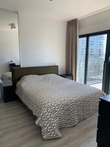 een slaapkamer met een bed en een groot raam bij AmazingView Apt Parking included in Rotterdam