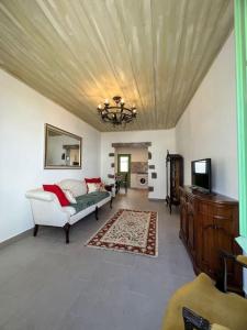 a living room with a couch and a television at Casa Porta Velha 2 Bed in Tavira