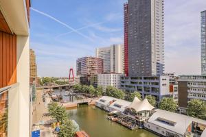 Blick auf einen Fluss in einer Stadt mit Gebäuden in der Unterkunft AmazingView Apt Parking included in Rotterdam