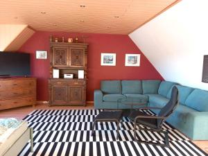un salon avec un canapé bleu et une télévision dans l'établissement FeWo-Haus-Junkernhof, à Medebach