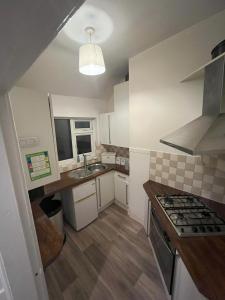 a small kitchen with a sink and a stove at Hollies House in Retford
