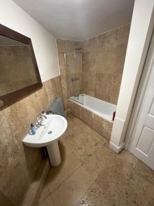 a bathroom with a sink and a bath tub at Hollies House in Retford