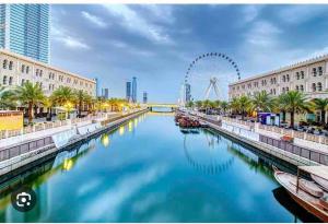 a river in a city with a ferris wheel in the background at Lovely 1 Bedroom near to beach in Sharjah