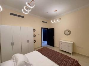 ein Schlafzimmer mit einem Bett und einer Uhr an der Wand in der Unterkunft Lovely 1 Bedroom near to beach in Schardscha