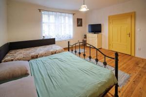 1 Schlafzimmer mit 2 Betten und einem TV in der Unterkunft Betlehem in Kyslá