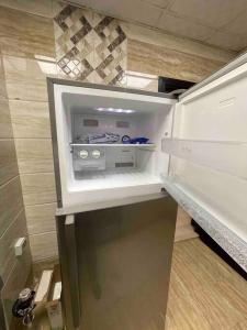 an empty refrigerator with its door open in a kitchen at Lovely 1 Bedroom near to beach in Sharjah