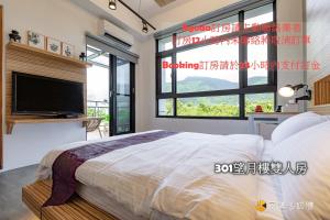 a bedroom with a large bed and a tv at Harbour Enjoy Homestay in Yilan City