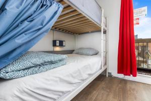 a bunk bed in a room with a red curtain at Samesun Toronto in Toronto