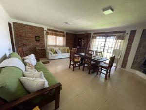 een woonkamer met een bank en een tafel en stoelen bij Paz Cerca de Termas Grandes in Gualeguaychú