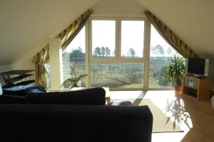 a living room with two couches and a large window at Ferienhaus Seeblick 39 in Holnishof