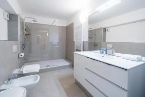 ein Bad mit einem Waschbecken, einem WC und einer Dusche in der Unterkunft Comacina Villa in Como
