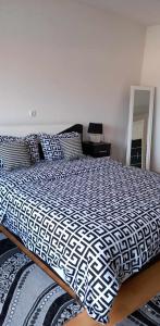 een bed met een zwart-wit dekbed in een slaapkamer bij Ferienwohnung Sabina in Bosanska Krupa
