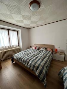 een slaapkamer met een bed met een dekbed erop bij Casa Caliman in Santa Caterina