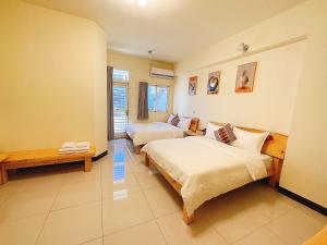 a hotel room with two beds and a couch at Yamada Heart B&B in Hualien City