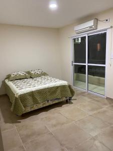 een slaapkamer met een bed in een kamer met een raam bij Dpto Costa Corrientes. 2 habitaciones. Cochera. in Corrientes