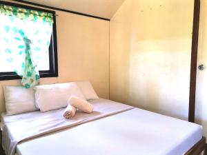 Łóżko w małym pokoju z oknem w obiekcie Villa Milanel Port Barton w mieście Port Barton