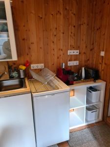 a kitchen with a white refrigerator and wooden walls at Kl. Cottage im Grünen, n. S-Bahn in Stuttgart