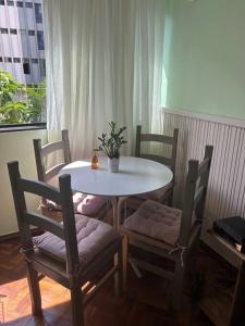 a dining room table and chairs with a white table and a plant at Casa de Ana - no coração de Bsb! in Brasilia