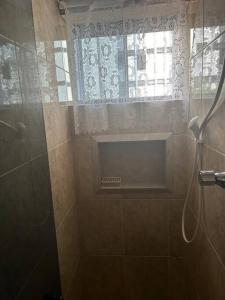 a bathroom with a shower with a window at Casa de Ana - no coração de Bsb! in Brasilia