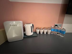 a counter with a coffee maker and bottles of water at Woco Hotel Kinrara in Puchong