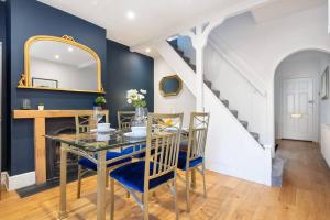 ein Esszimmer mit einem Tisch und einer Treppe in der Unterkunft Newly Renovated 2 Bed Cottage - Long Stay Reduce Rate in Windsor