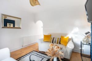 a living room with a white couch and yellow pillows at Newly Renovated 2 Bed Cottage - call for discount in Windsor