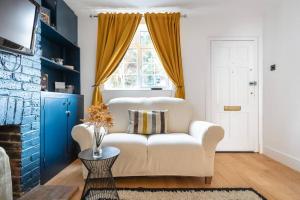 ein Wohnzimmer mit einer weißen Couch und einem Fenster in der Unterkunft Newly Renovated 2 Bed Cottage - Long Stay Reduce Rate in Windsor