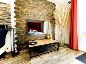 uma sala de estar com uma parede de tijolos e uma mesa de centro em Appartement Propriano Corse du Sud Face à la Mer em Propriano