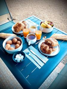 uma mesa azul com alimentos e bebidas para o pequeno almoço em Appartement Propriano Corse du Sud Face à la Mer em Propriano