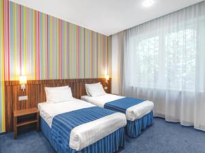 a hotel room with two beds and a window at Rija VEF Hotel with FREE Parking in Rīga