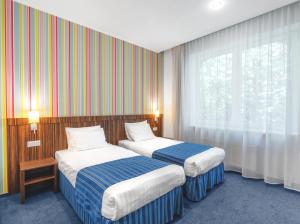 a hotel room with two beds and a window at Rija VEF Hotel with FREE Parking in Riga