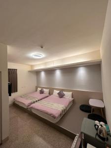 a bedroom with a bed with pink sheets and pillows at Royal Yado in Zhixue +3 photos