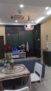 ein Wohnzimmer mit einem Tisch und einem TV in der Unterkunft Doris Hotel in Malakka