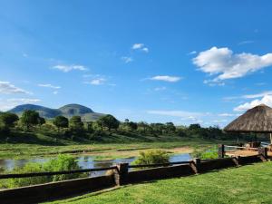 a view of a river and a hut at River Cottage Lodge in Malelane