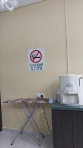 uma mesa com um sinal de não fumar na parede em Doris Hotel em Malaca