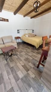 Un dormitorio con una cama, un sofá y una mesa. en Los Cardales, en Cachí