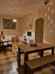 Una sala de estar con una mesa y un televisor. en Daldeia, en São Pedro da Aldeia