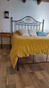 Una cama con una manta amarilla encima. en Los Cardales, en Cachí 4 fotos más