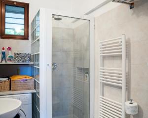 La salle de bains est pourvue d'une douche avec une porte en verre. dans l'établissement Casa del Pastore, à Stellanello