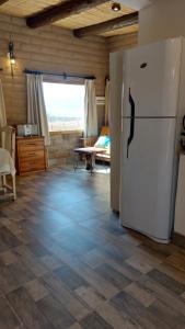 Una cocina con un refrigerador blanco en una habitación. en Los Cardales, en Cachí
