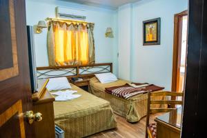 pokój hotelowy z 2 łóżkami i oknem w obiekcie Assiutel w mieście Asjut