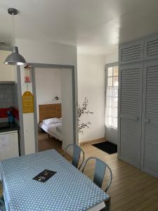 La Guérinière的住宿－Studio Noirmoutier Plage，一间带桌子的厨房和一间带床的卧室