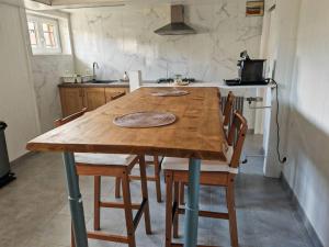 - une table et des chaises en bois dans la cuisine dans l'établissement Appartement au sein d'une maison, à Issenheim