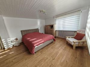 - une chambre avec un lit et une chaise dans l'établissement Appartement au sein d'une maison, à Issenheim