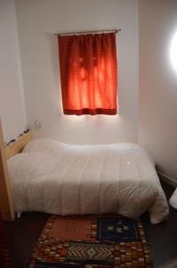 Schlafzimmer mit einem Bett, einem Fenster und einem Teppich in der Unterkunft Chalet, calme, absolu, superbe vue, et piscine (en été) in Ventenac-Cabardès