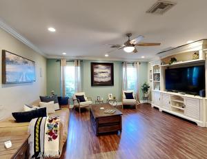 een woonkamer met een bank en een flatscreen-tv bij The Sea Star in Fort Myers