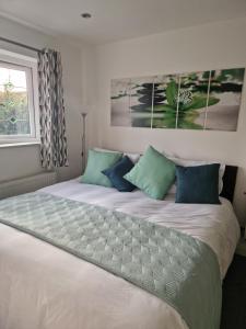 a bedroom with a large white bed with blue pillows at Posyrooms in Manchester