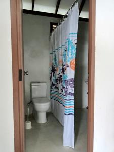 a bathroom with a toilet and a shower curtain at Palm Beach Resort Ceylon in Jaffna
