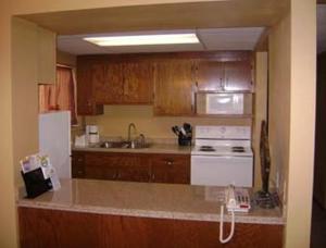 una cucina con armadi in legno e un piano cottura bianco con forno di Sunset Inn & Suites a Lincoln