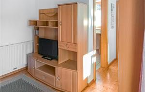 a wooden entertainment center with a television in a room at Beautiful Apartment In Patsch With Wifi And 2 Bedrooms in Innsbruck